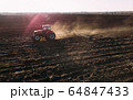 Farm tractor raising dust with harrow plow preparing land for sowing. Agriculture industry, cultivation of land. 64847433
