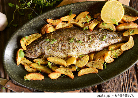 Roasted trout with potatoes in thyme Roasted trout with potatoes in thyme 64848976