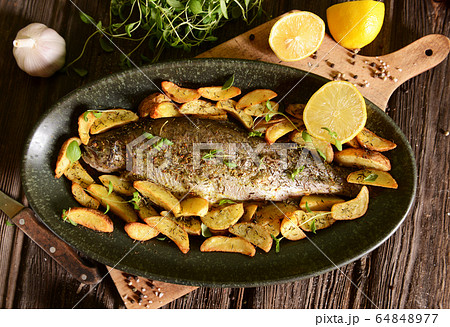 Roasted trout with potatoes in thyme 64848977