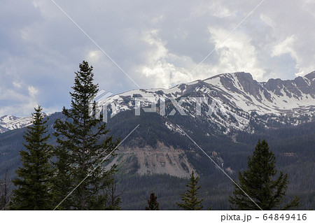 A view of the snow covered Colorado mountains and cloudy skies A view of the snow covered Colorado mountains and cloudy skies 64849416
