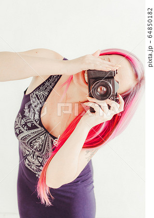 photographer girl with pink hair on a photo shoot with a camera photographer girl with pink hair on a photo shoot with a camera 64850182