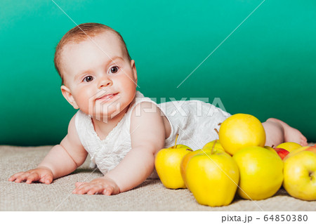 baby girl in a dress with Green apples baby girl in a dress with Green apples 64850380