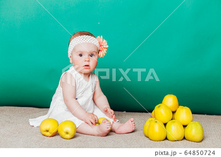 baby girl in a dress with Green apples baby girl in a dress with Green apples 64850724