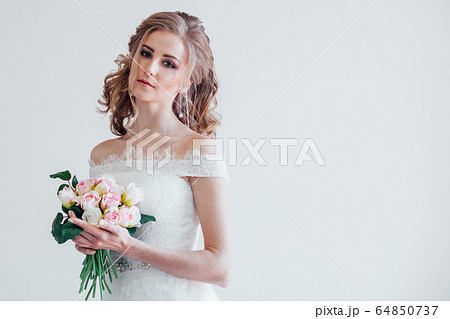 bride in wedding dress holding a bouquet of flowers bride in wedding dress holding a bouquet of flowers 64850737