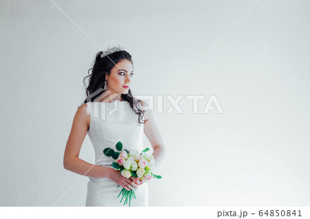 bride in white wedding dress with a bouquet of flowers 64850841