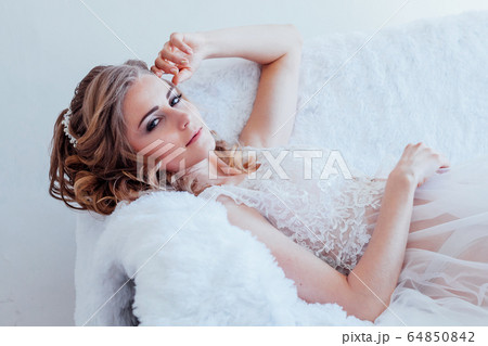 Portrait of a beautiful girl lying on a sofa 64850842