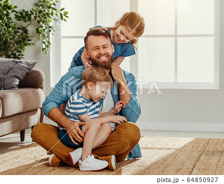 Happy dad and kids embracing at home. 64850927