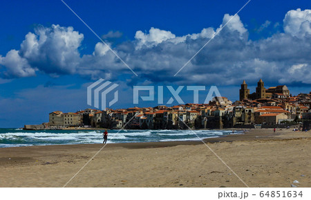 the beach of Cefalu leading to its old town, Sicily. Its a sunny spring day 64851634