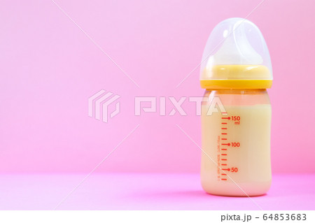 ピンクの背景と哺乳瓶とおもちゃ 64853683