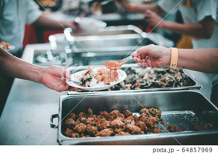 People holding a plate receiving a donation from a 64857969