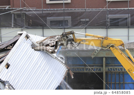 建物の解体現場　解体用つかみ機　放水中 64858085