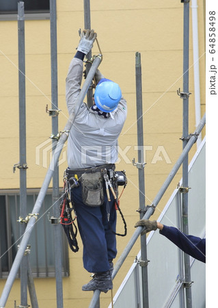 建物の解体現場　防護柵を取り外す作業員 　 64858498