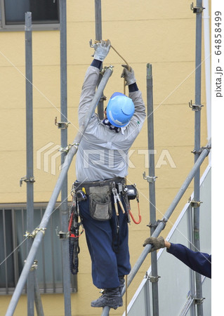 建物の解体現場　防護柵を取り外す作業員 　 64858499