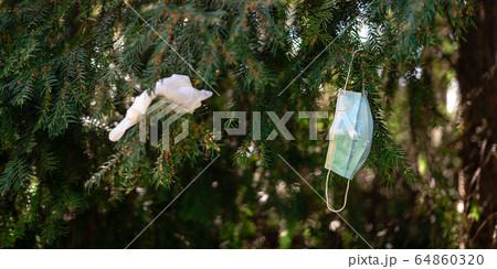 Medical mask on the tree outdoors. Pollution from covid-19 quarantine Medical mask on the tree outdoors. Pollution from covid-19 quarantine 64860320