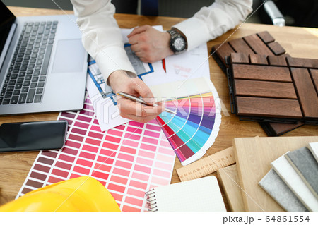 Male designer hand hold silver pen against color palette trend 64861554