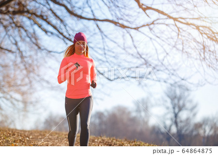 Young slim woman running in park in the morning 64864875