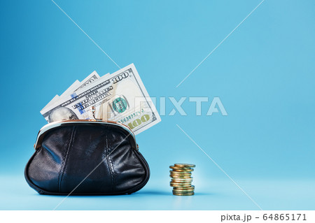 Black wallet with coins and dollars on a blue 64865171