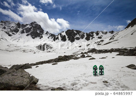 Pair of green snowshoes in snow. High snowy 64865997