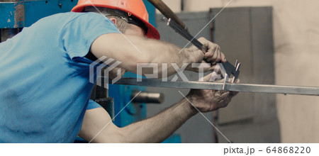 Worker using a Vernier Caliper measurement of 64868220