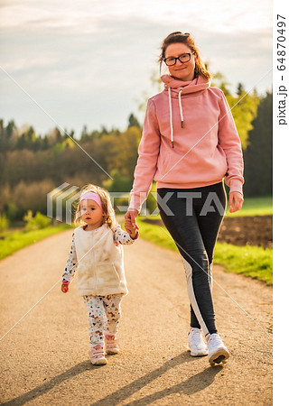 Mother and child walking on countryside road Mother and child walking on countryside road 64870497