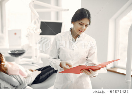 Beautiful dentist working on a dental clinic 64871422
