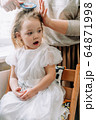 mother makes hair for her little daughter 64871998