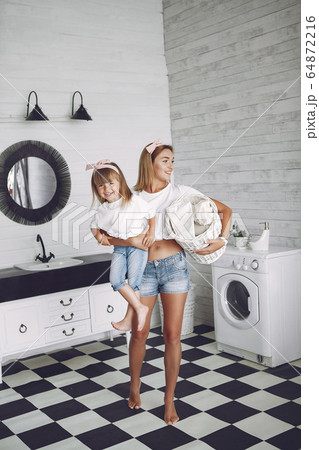 Mother and daughter in a bathroom near wash mashine Mother and daughter in a bathroom near wash mashine 64872216