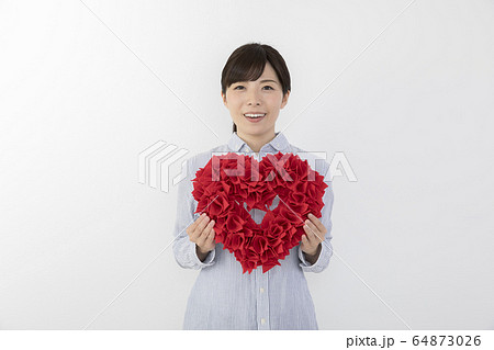 ハートを持つ若い女性 64873026