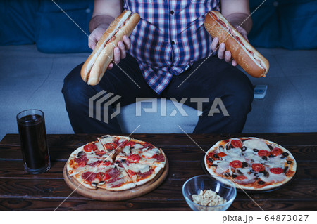 Overweight man with big amount of junk food 64873027