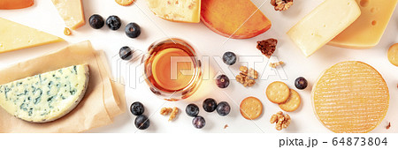 Cheese and wine tasting and pairing flat lay panorama on a white background with a place for text. Many different cheeses, shot from above 64873804