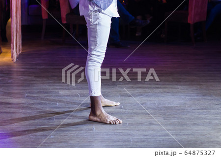 Dancing shoes feet and legs of male ballroom and latin salsa dancer dance teacher on the stage. Social dance, bachata solo and kizomba concept Dancing shoes feet and legs of male ballroom and latin salsa dancer dance teacher on the stage. Social dance, bachata solo and kizomba concept 64875327