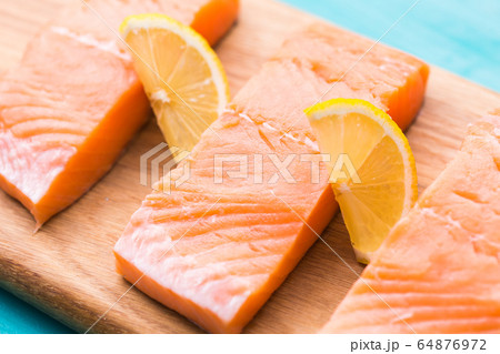 Fresh raw salmon on wooden cutting board. Fresh raw salmon on wooden cutting board. 64876972