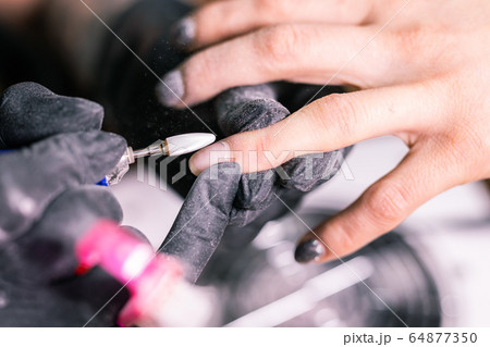 Close-up automatic electric manicure drill polish remover for nail women. Nail, gel polish and beauty salon concept. Close-up automatic electric manicure drill polish remover for nail women. Nail, gel polish and beauty salon concept. 64877350