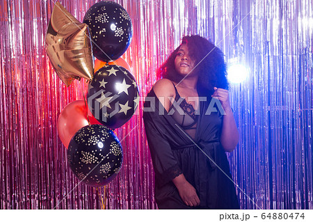 Beautiful black woman enjoying a party lifestyle. Birthday party, clubbing and holidays concept. Beautiful black woman enjoying a party lifestyle. Birthday party, clubbing and holidays concept. 64880474