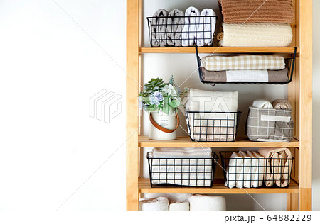 Bed sheets, duvet covers and towels are folded vertically. Metal and fabric black baskets. The concept of housework and storage. Bed sheets, duvet covers and towels are folded vertically. Metal and fabric black baskets. The concept of housework and storage. 64882229