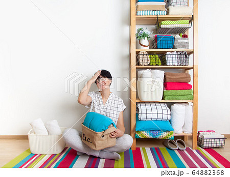 Bed sheets, duvet covers and towels are folded vertically. Metal and fabric black baskets. Bedclothes bright colors. 64882368