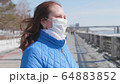 A girl in a protective mask on the street. Prevention and protection of health and safety of life. 64883852