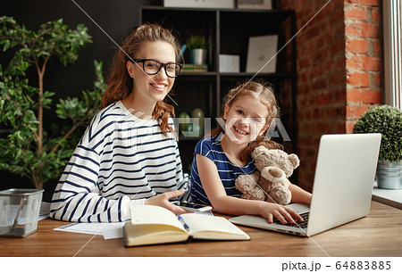 Girl and young mother working at laptop. 64883885