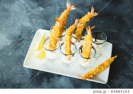 Sea food dish with grilled king prawn served with sauce and slice of lemon. Sea food dish with grilled king prawn served with sauce and slice of lemon. 64884103