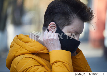 Middle aged european woman in protective black Middle aged european woman in protective black 64885664