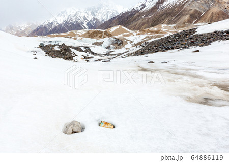 Garbage scattered over snowy mountain. Let's save the planet and recycle the excess garbage. Pollution Concept 64886119