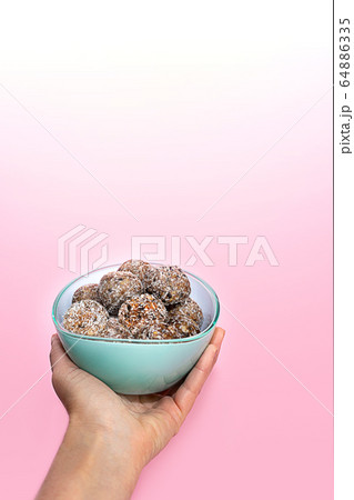Hand with healthy energy balls or protein peanut butter energy bites. Hand with healthy energy balls or protein peanut butter energy bites. 64886335