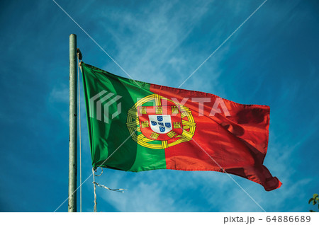Portuguese flag fluttering in the blue sky 64886689