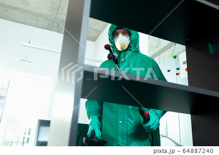 Experienced specialist disinfecting frequently touched surfaces indoors Experienced specialist disinfecting frequently touched surfaces indoors 64887240