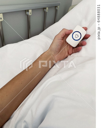 Female patient holding nurse call button in hospital room Female patient holding nurse call button in hospital room 64888031