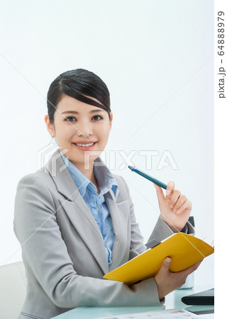 手帳を手に笑顔の仕事中の若い女性 03の写真素材 6479