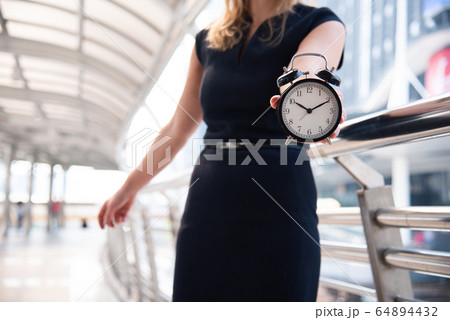Business women show alarm clock and shocked with Business women show alarm clock and shocked with 64894432