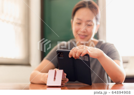 Social distancing happy smiling woman using cell phone video call family. Social distancing happy smiling woman using cell phone video call family. 64894908