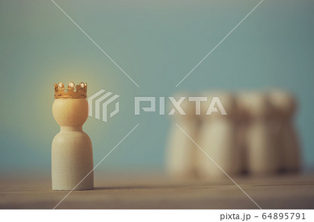 Successful business team leader concept: Wooden figures of man and people donned the crown standing out from crowd. depicts ability of an individual to influence and lead followers of other members Successful business team leader concept: Wooden figures of man and people donned the crown standing out from crowd. depicts ability of an individual to influence and lead followers of other members 64895791