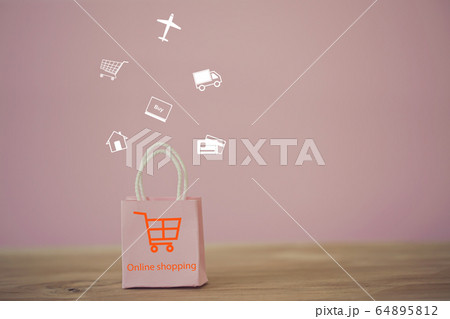 Shopping Online and e-commerce concept: Pink paper shopping bags with shopping cart icon on table. Online stores are considered as another medium of trading goods between entrepreneurs and customers. Shopping Online and e-commerce concept: Pink paper shopping bags with shopping cart icon on table. Online stores are considered as another medium of trading goods between entrepreneurs and customers. 64895812